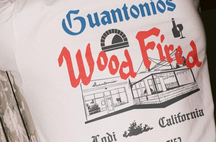 A white t-shirt with black, blue and red screen printing.