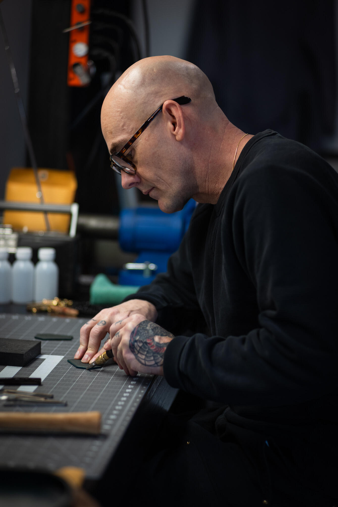 Leroy's House of Merch Logo Ryan Price working at a shop table on product materials